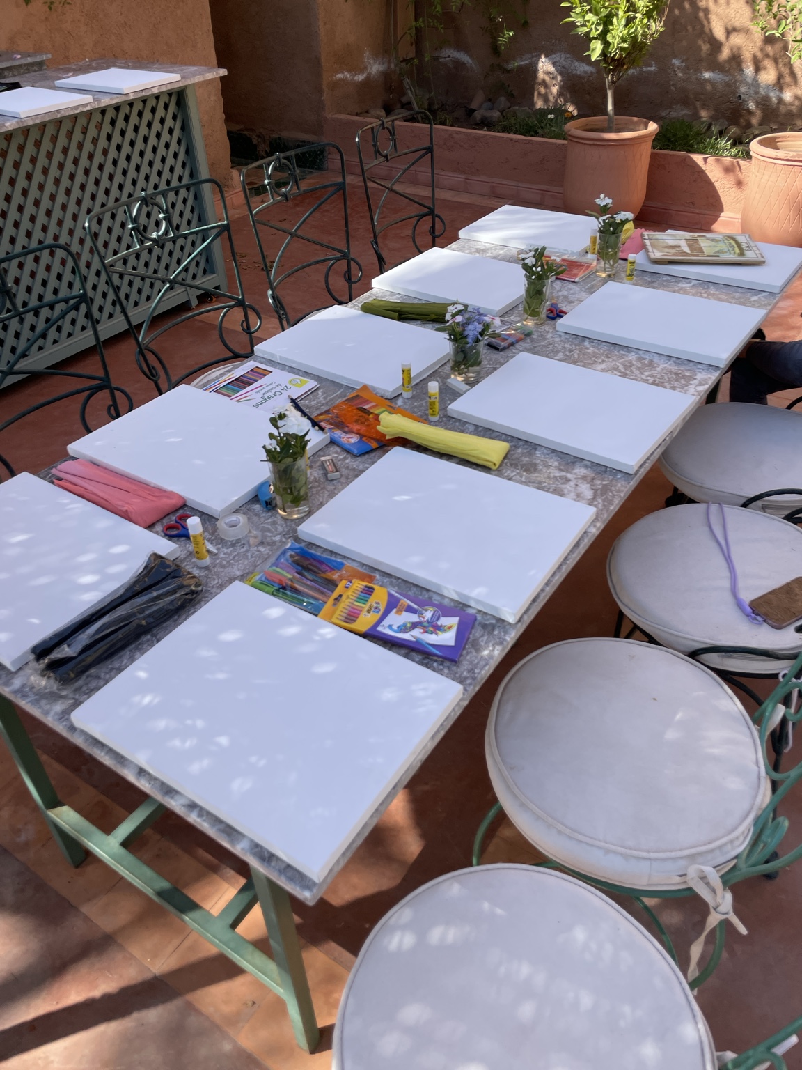 Une table préparée avec des toiles, des fleurs et du matériel créatif